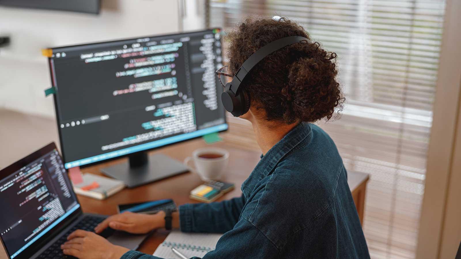 Student looking at code on two monitors representing Computer Science programs at esball国际平台客户端